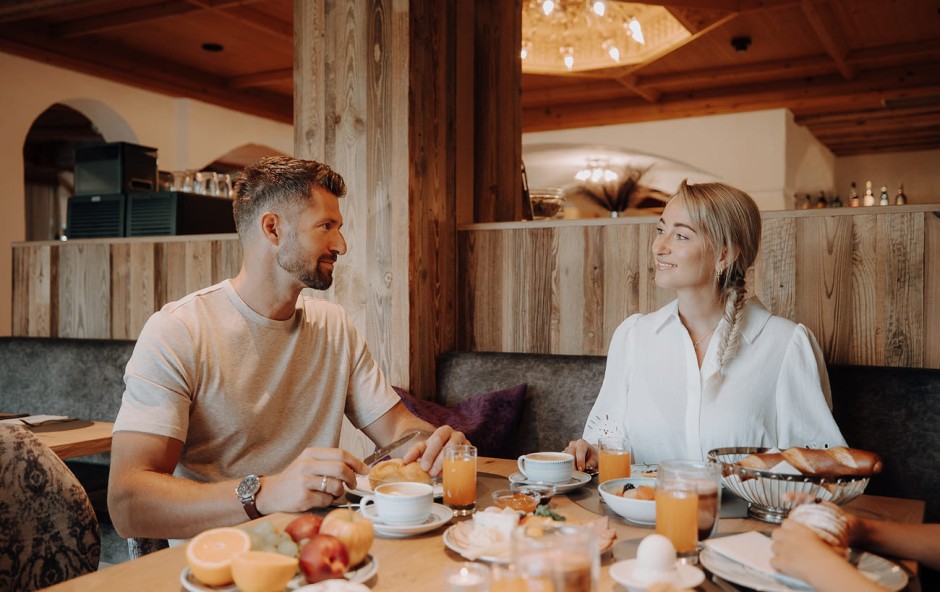 Paar fr&uuml;hst&uuml;ckt l&auml;chelnd im gem&uuml;tlichen Dorfer-Restaurant