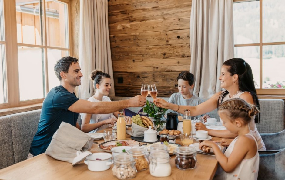 Familie beim gem&uuml;tlich Fr&uuml;hst&uuml;cken im Chalet Lois